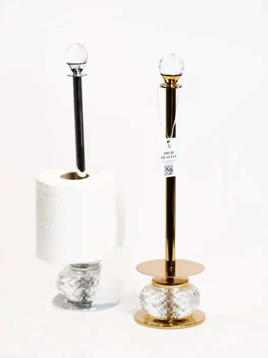 دو استند دستمال حوله رومیزی کریستال در کنار هم در رنگ های مختلف طلایی و استیل با دستمال توالت آویخته در یکی از آنها